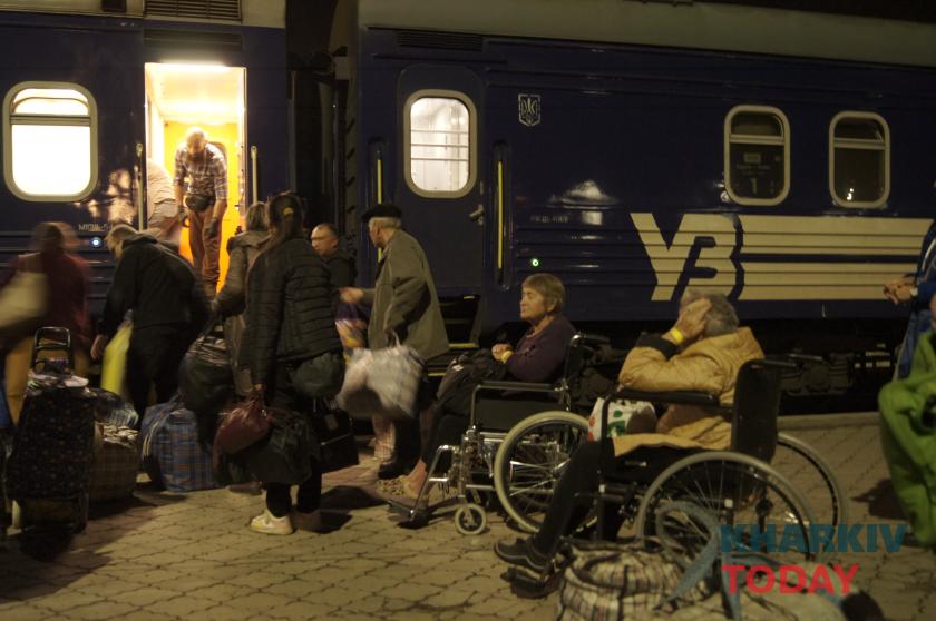 Волонтери допомагають маломобільним евакуйованим під час пересадки.